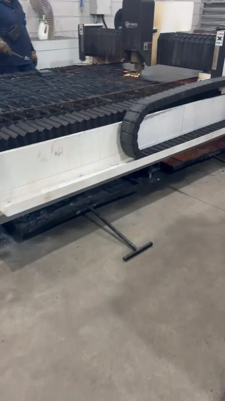 Cabeçote de corte sobre chapa metálica apoiada na mesa da máquina.