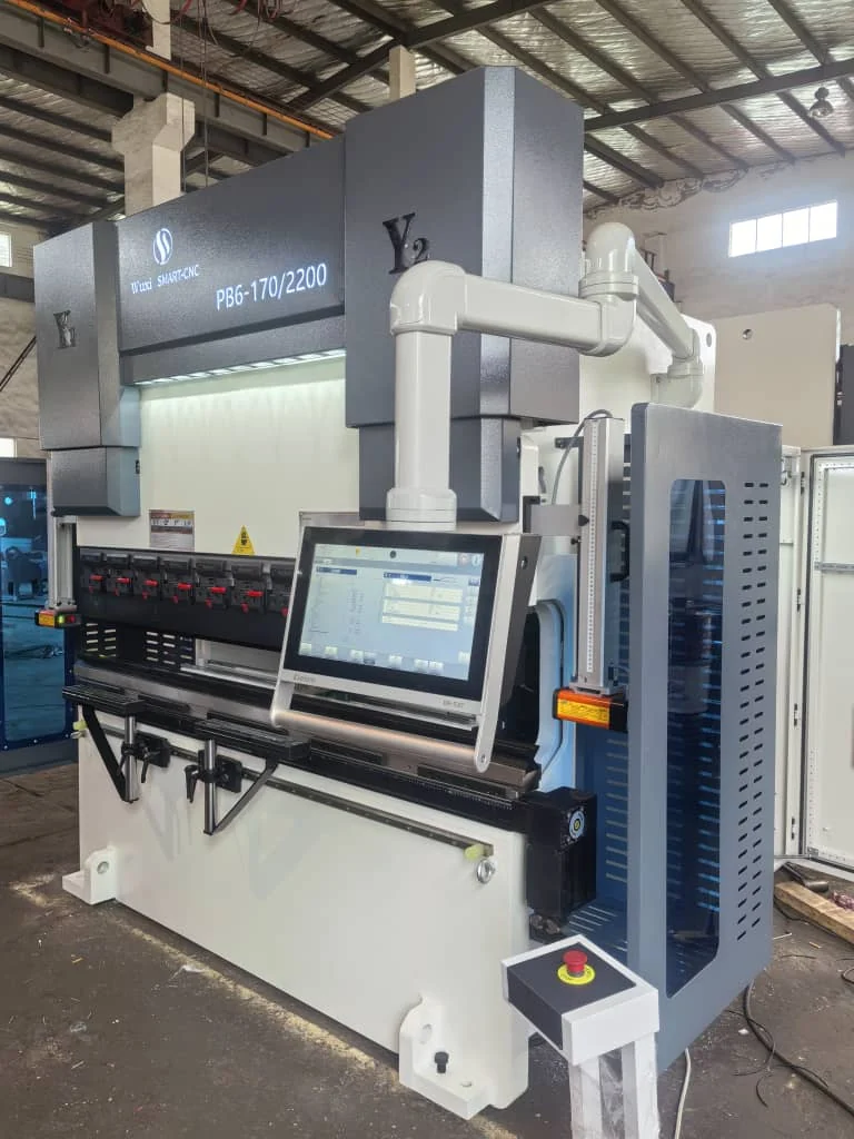 Dobradeira industrial com ferramental frontal, painel de comando e proteção lateral.