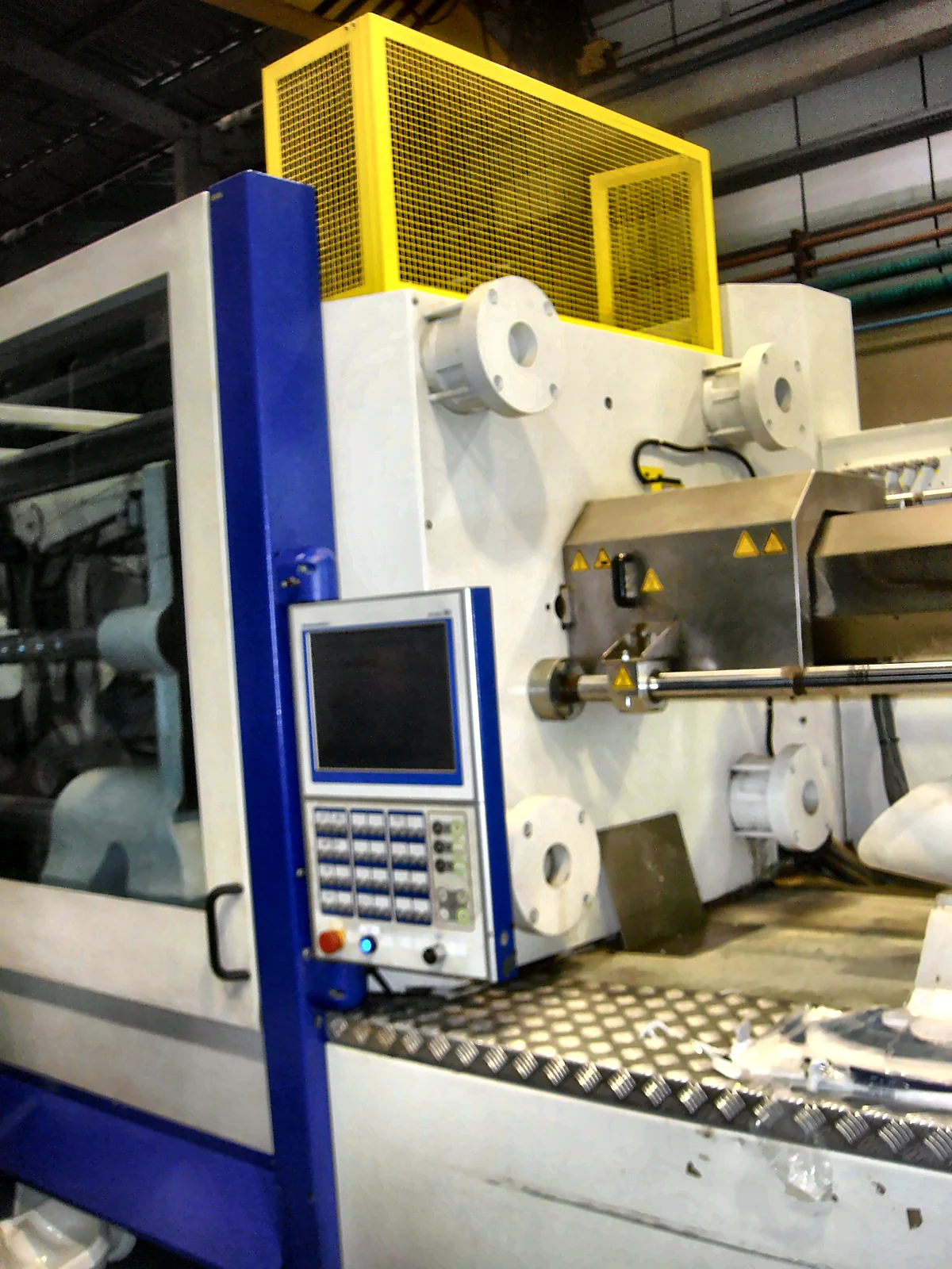 Injetora de plástico com painel de operação, porta com visor e proteção superior amarela